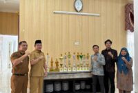 Wali Kota Payakumbuh Zulmaeta (kedua kiri) berfoto bersama jajaran guru SD IT IPHI Payakumbuh saat memperlihatkan deretan piala yang diraih Marching Band Gema Nada sebagai Juara Umum Junior Brass pada Kejuaraan Marching Band Piala Raja Hamengkubuwono X 2025 di Yogyakarta, Selasa (14/10/2025).