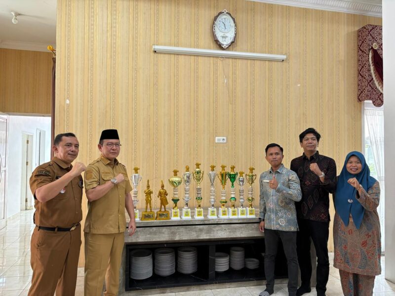Wali Kota Payakumbuh Zulmaeta (kedua kiri) berfoto bersama jajaran guru SD IT IPHI Payakumbuh saat memperlihatkan deretan piala yang diraih Marching Band Gema Nada sebagai Juara Umum Junior Brass pada Kejuaraan Marching Band Piala Raja Hamengkubuwono X 2025 di Yogyakarta, Selasa (14/10/2025).