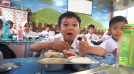 Siswa sekolah dasar di salah satu ruang kelas menikmati makanan dari program Makan Bergizi Gratis, Jumat (03/10/2025). Meski terlihat ceria, program ini menuai kritik setelah maraknya kasus keracunan massal dan dugaan keuntungan miliaran rupiah bagi pengusaha penyedia layanan.