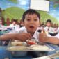 Siswa sekolah dasar di salah satu ruang kelas menikmati makanan dari program Makan Bergizi Gratis, Jumat (03/10/2025). Meski terlihat ceria, program ini menuai kritik setelah maraknya kasus keracunan massal dan dugaan keuntungan miliaran rupiah bagi pengusaha penyedia layanan.