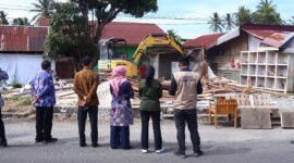 Sejumlah pejabat dan petugas Dinas Pekerjaan Umum dan Penataan Ruang (PUPR) Kota Payakumbuh menyaksikan proses pembongkaran bangunan tanpa izin yang berdiri di atas tanah milik Pemerintah Kota Payakumbuh, kawasan Jalan Imam Bonjol, Kelurahan Padangdata Tanahmati, Kamis (13/11/2025).