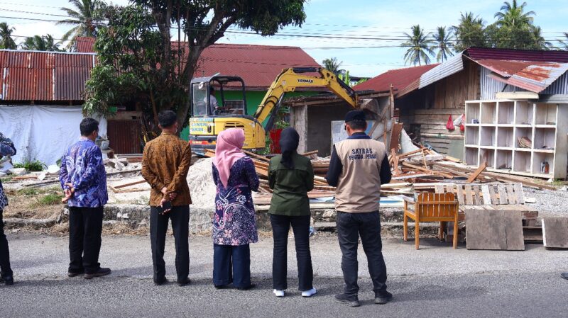 Sejumlah pejabat dan petugas Dinas Pekerjaan Umum dan Penataan Ruang (PUPR) Kota Payakumbuh menyaksikan proses pembongkaran bangunan tanpa izin yang berdiri di atas tanah milik Pemerintah Kota Payakumbuh, kawasan Jalan Imam Bonjol, Kelurahan Padangdata Tanahmati, Kamis (13/11/2025).